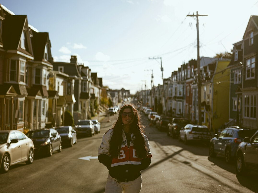Portrait of the lead photographer of Life On Canadian Streets standing outdoors with a camera around her neck