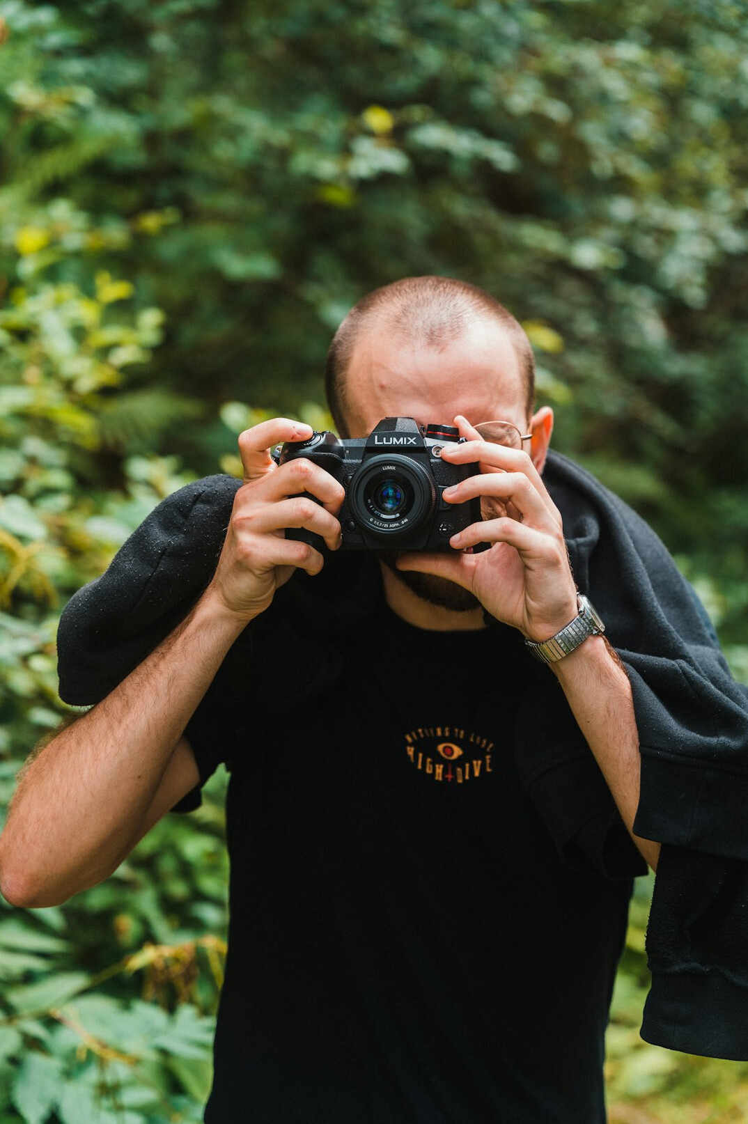 Portrait of a French-Canadian man photographer smiling softly against a warm neutral background