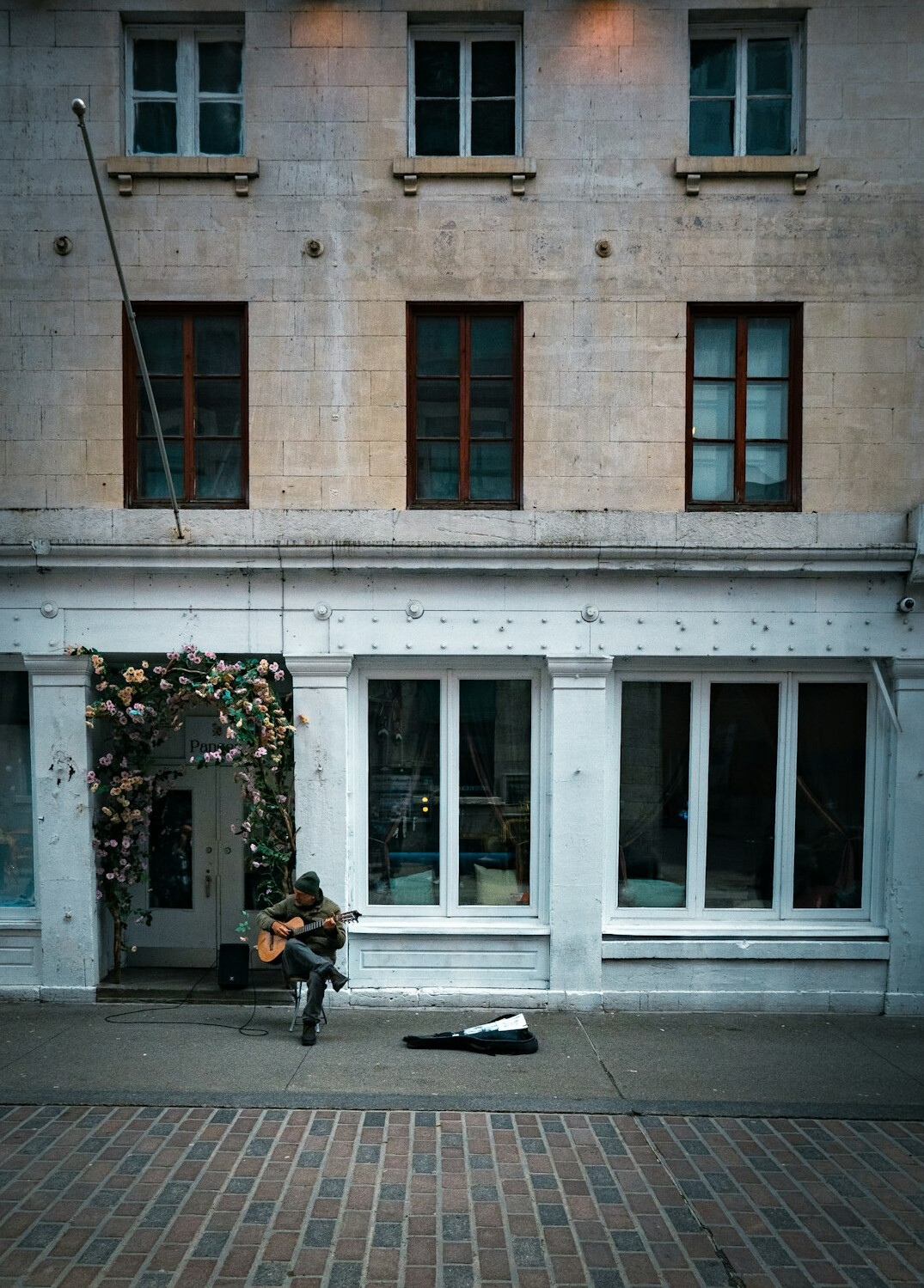 A photographer crouched down on a Montreal street capturing passersby with a handheld camera